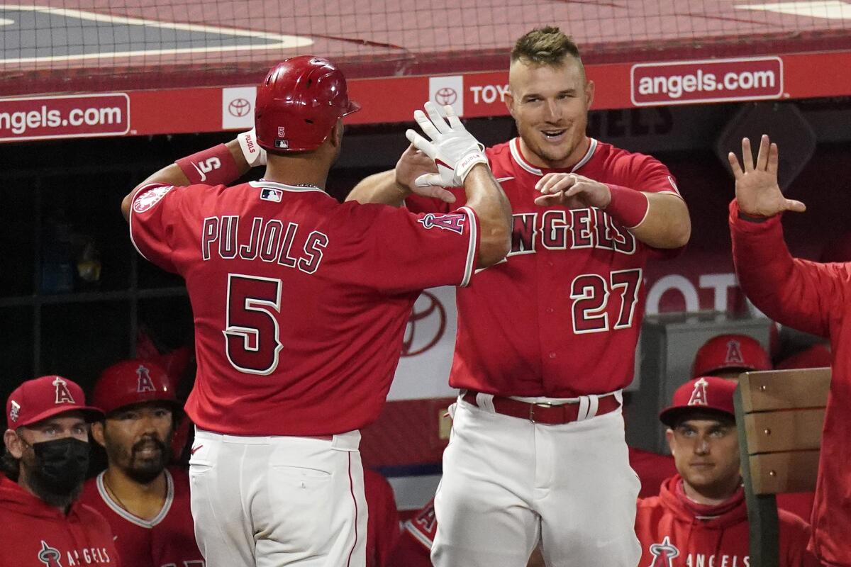 Albert Pujols and Mike Trout raise both hands for a double high-five.