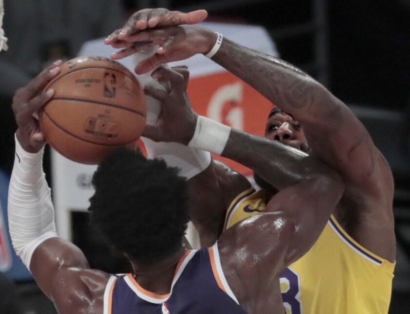 Lakers forward LeBron James blocks the shot of Suns center Deandre Ayton.