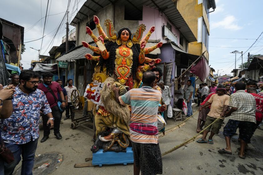 Laborers pull a clay idol of Hindu goddess Durga to load on a truck ahead of Durga Puja festival at Kumortuli, the potters' place, in Kolkata, India, Sept. 26, 2022. The five-day festival commemorates the slaying of a demon king by goddess Durga, marking the triumph of good over evil. (AP Photo/Bikas Das)