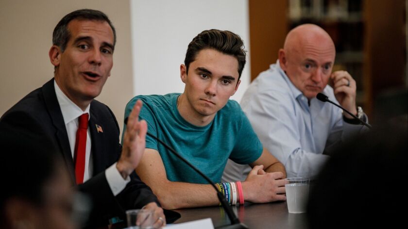 David Hogg, center, a survivor of the school shooting in Parkland, Fla., listens to Los Angeles Mayor Eric Garcetti, left, during a round table. On the right is retired astronaut and gun-control activist Mark Kelly.