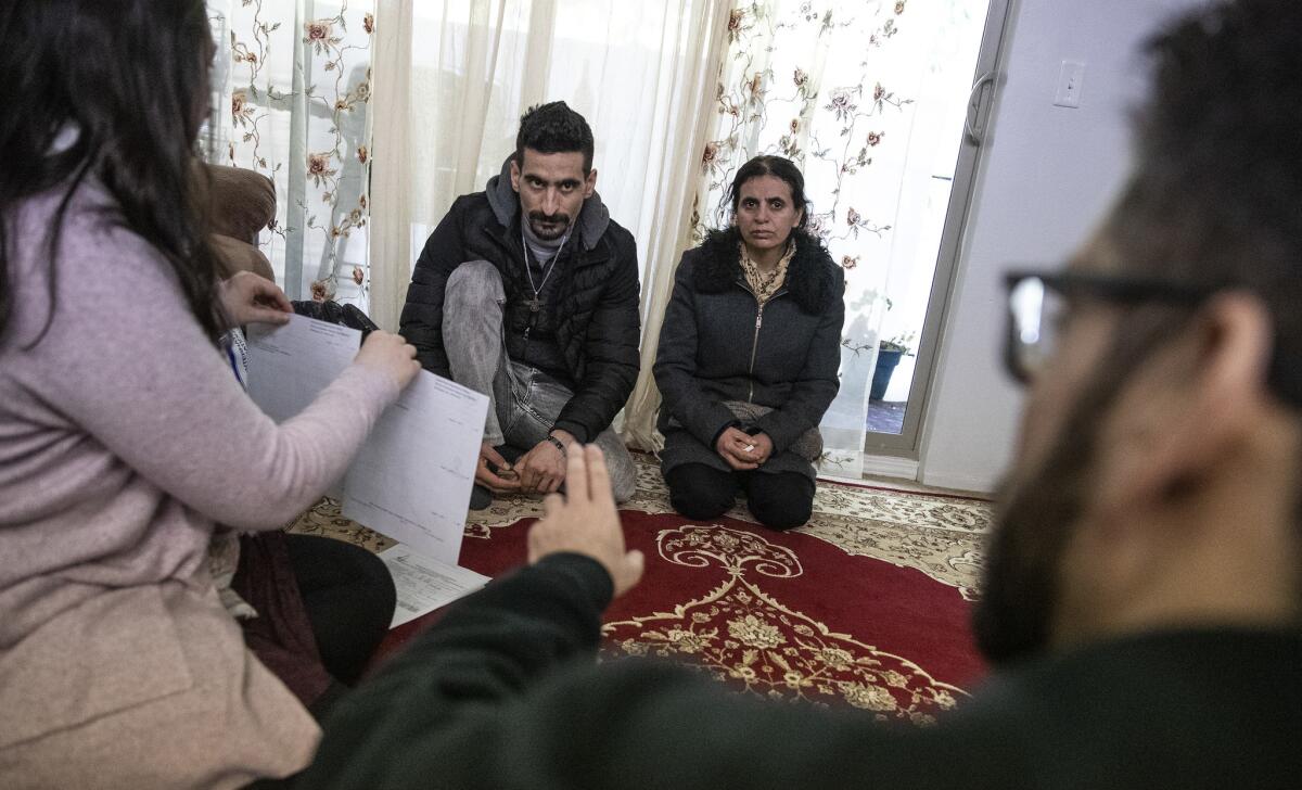 Iranian refugees Sirvan Moradi and Saltanat Moradi meet with International Rescue Committee workers at friend Masoud Veysi's home in Kent, Wash.