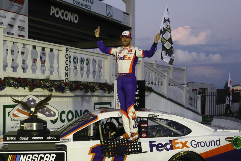 Denny Hamlin celebrates after winning the NASCAR Cup Series auto race at Pocono Raceway.