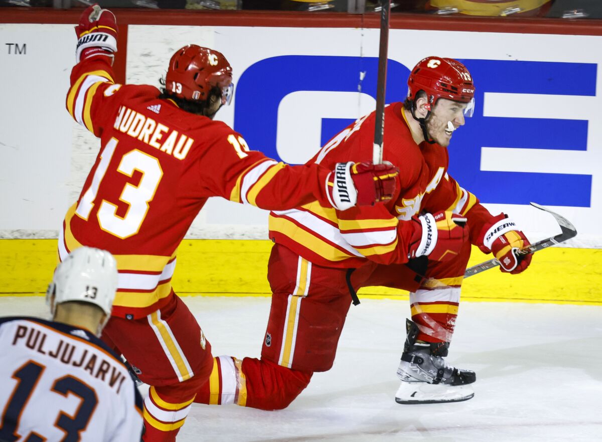 Calgary Flames forward Matthew Tkachuk, right, celebrates his goal against the Edmonton Oilers with forward Johnny Gaudreau during the third period of Game 1 of an NHL hockey second-round playoff series Wednesday, May 18, 2022, in Calgary, Alberta. (Jeff McIntosh/The Canadian Press via AP)