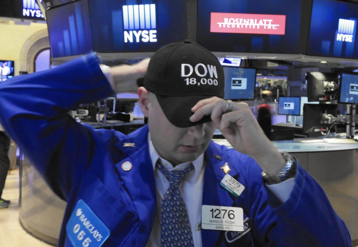 Mario Picone adjusts his Dow 18,000 cap as he works the floor of the New York Stock Exchange.