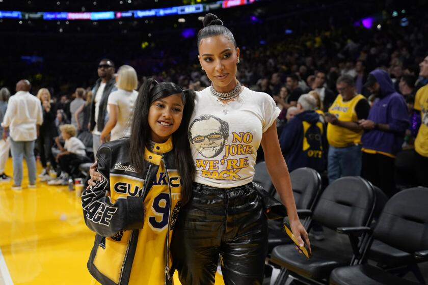 Kim Kardashian is posing with her daughter North West next to the basketball court at Crypto.com Arena for a Lakers game.