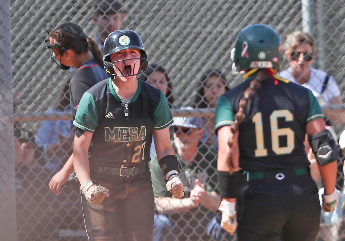 Murrieta Mesa's Taelyn Holley (27) reacts to sliding into home for a run with Victoria Prado (16) on Thursday.