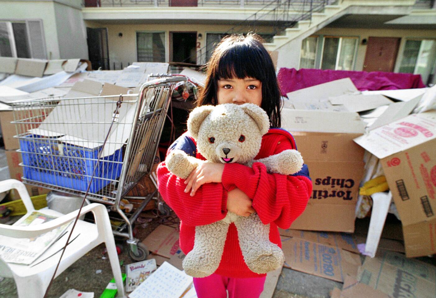 Jessica Hernandez, 7, clutches her teddy bear outside the makeshift shelter where her family and other residents of a Van Nuys apartment complex are living because they are afraid of return to their homes.