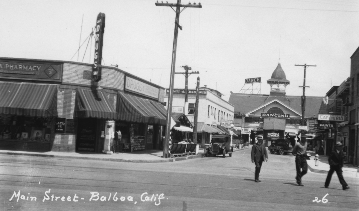 A photo of the Balboa Peninsula's Main Street. To the left, the Balboa Pharmacy is pictured. The date is unclear.