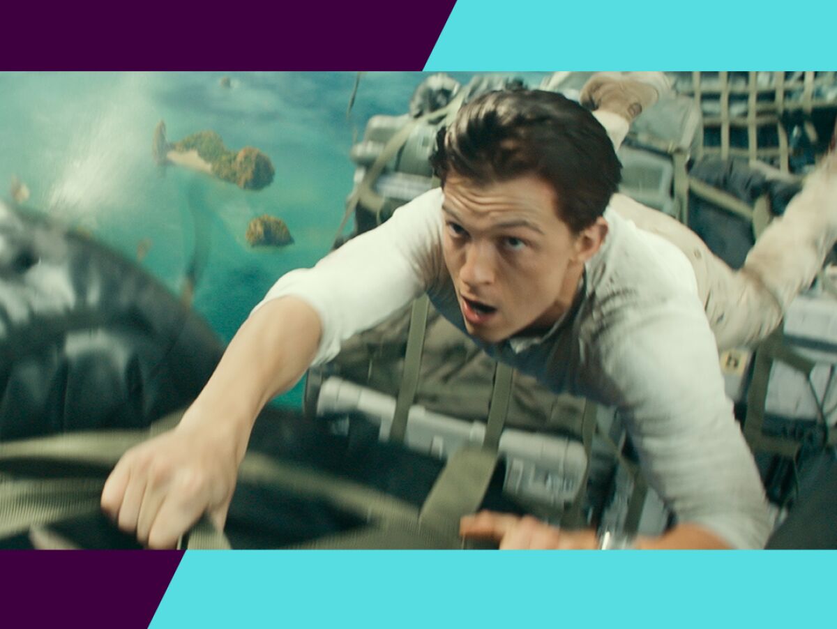 Tom Holland hangs onto the side of a building in a scene from "Uncharted."