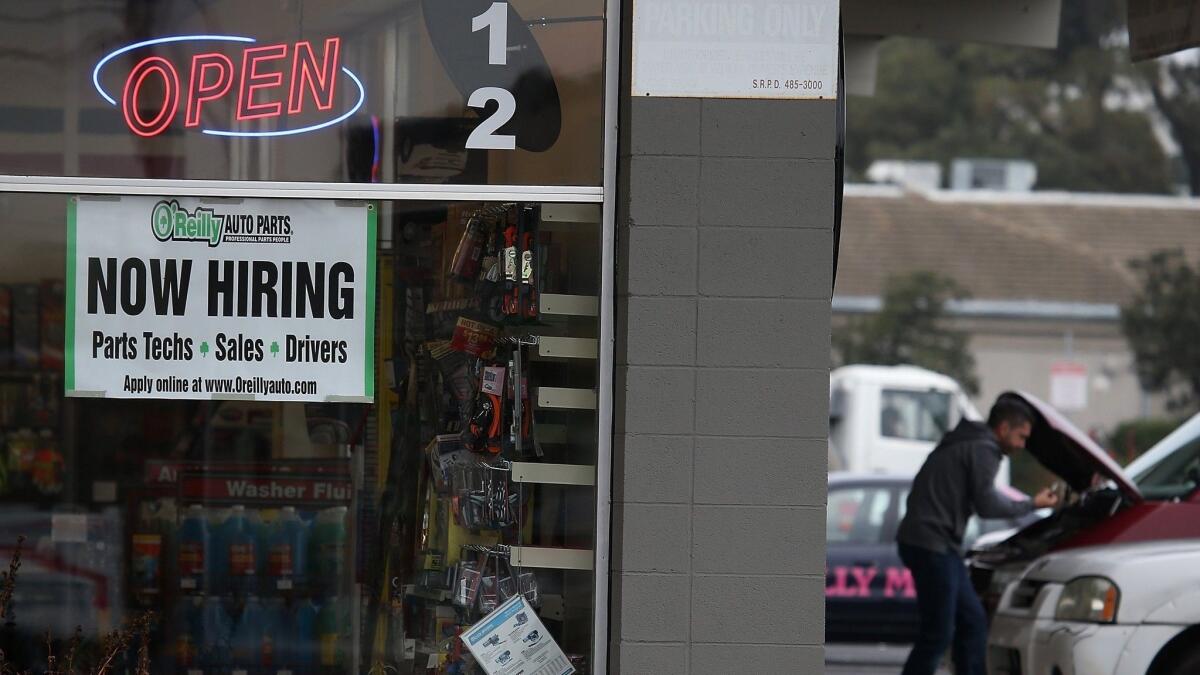 A Now Hiring sign is posted in window of an O'Reilly auto parts store in San Rafael in 2014.