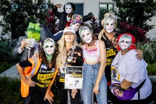 Los Angeles, CA - October 31: Frances Fisher, a member of SAG for nearly 50 years and currently one of the negotiators for SAG-AFTRA, center, without a mask, poses with people wearing masks with Fisher's face, while walking the Halloween line during the SAG-AFTRA picket, in front of Netflix in Los Angeles, CA, Tuesday, Oct. 31, 2023. (Jay L. Clendenin / Los Angeles Times)