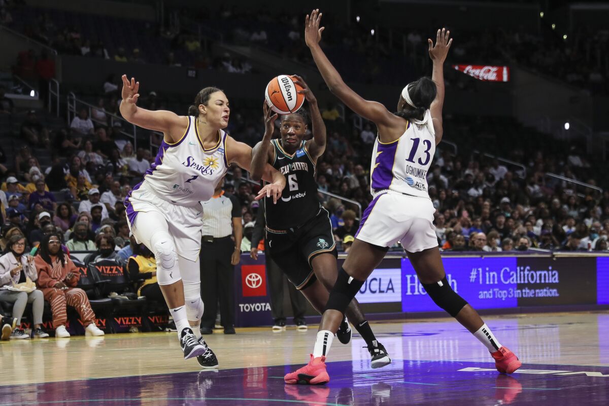New York's Natasha Howard tries to drive past Sparks defenders Liz Cambage (1) and Chiney Ogwumike (13).
