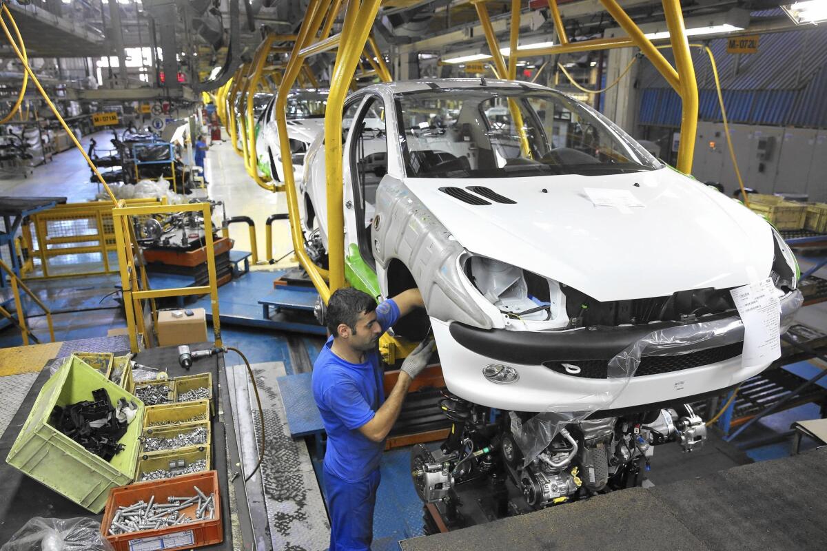 An Iranian worker assembles a Peugeot at a state-run plant near Tehran in 2014.