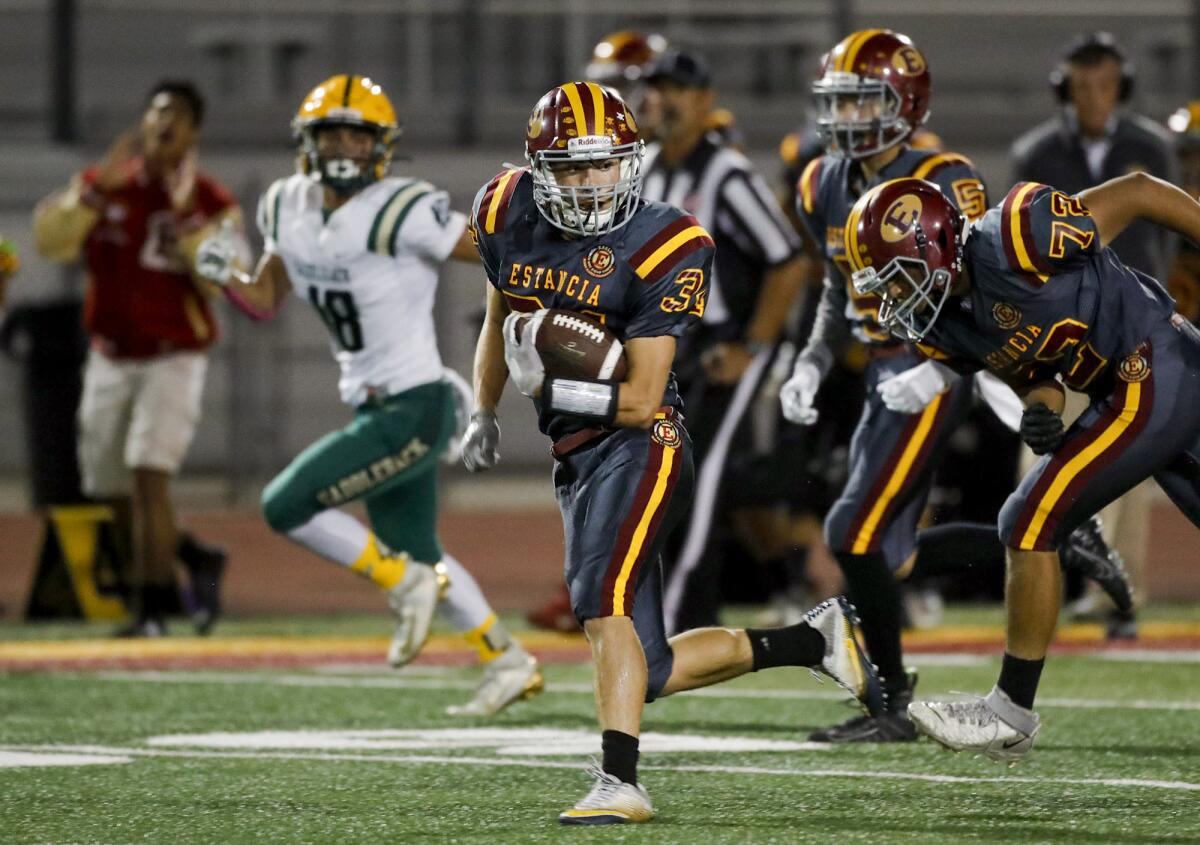 Estancia's Andrew Coyotzi (34) breaks into the secondary and heads for the end zone for a touchdown.