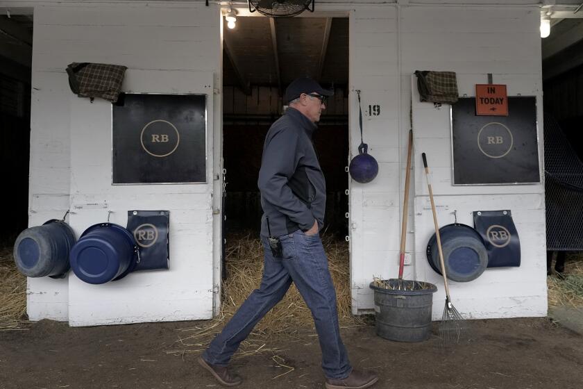 Trainer Tim Yakteen walks though his barn after taking Kentucky Derby entrants Tabia and Messier for workouts