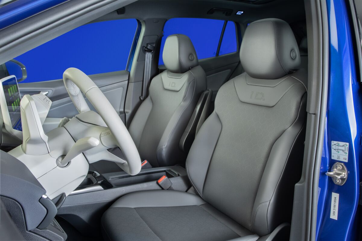 The white interior of the Volkswagen ID.4 showing front seats and steering wheel