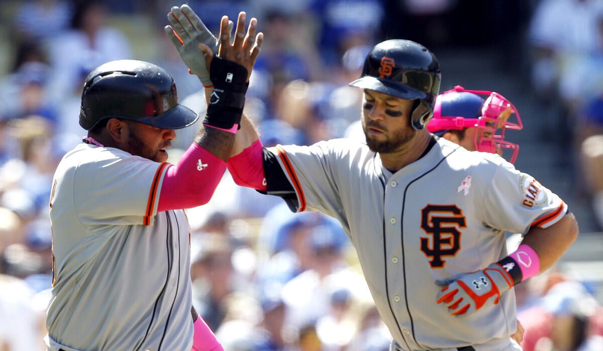 Giants second baseman Brandon Hicks, right, is congratulated by third baseman Pablo Sandoval after hitting a two-run home run in the seventh inning Sunday.