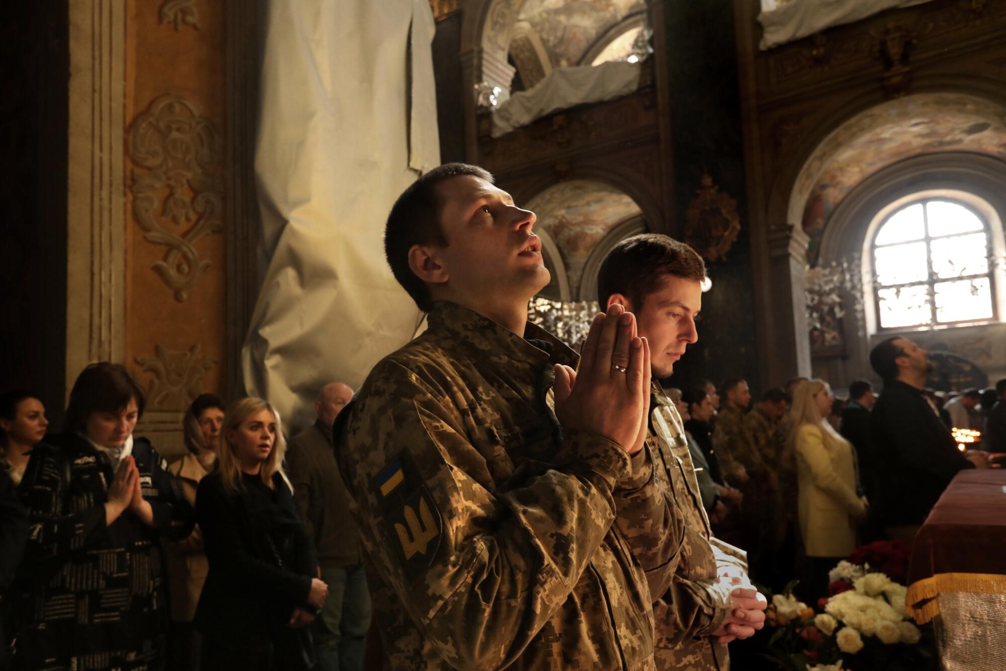 A soldier prays during a church service