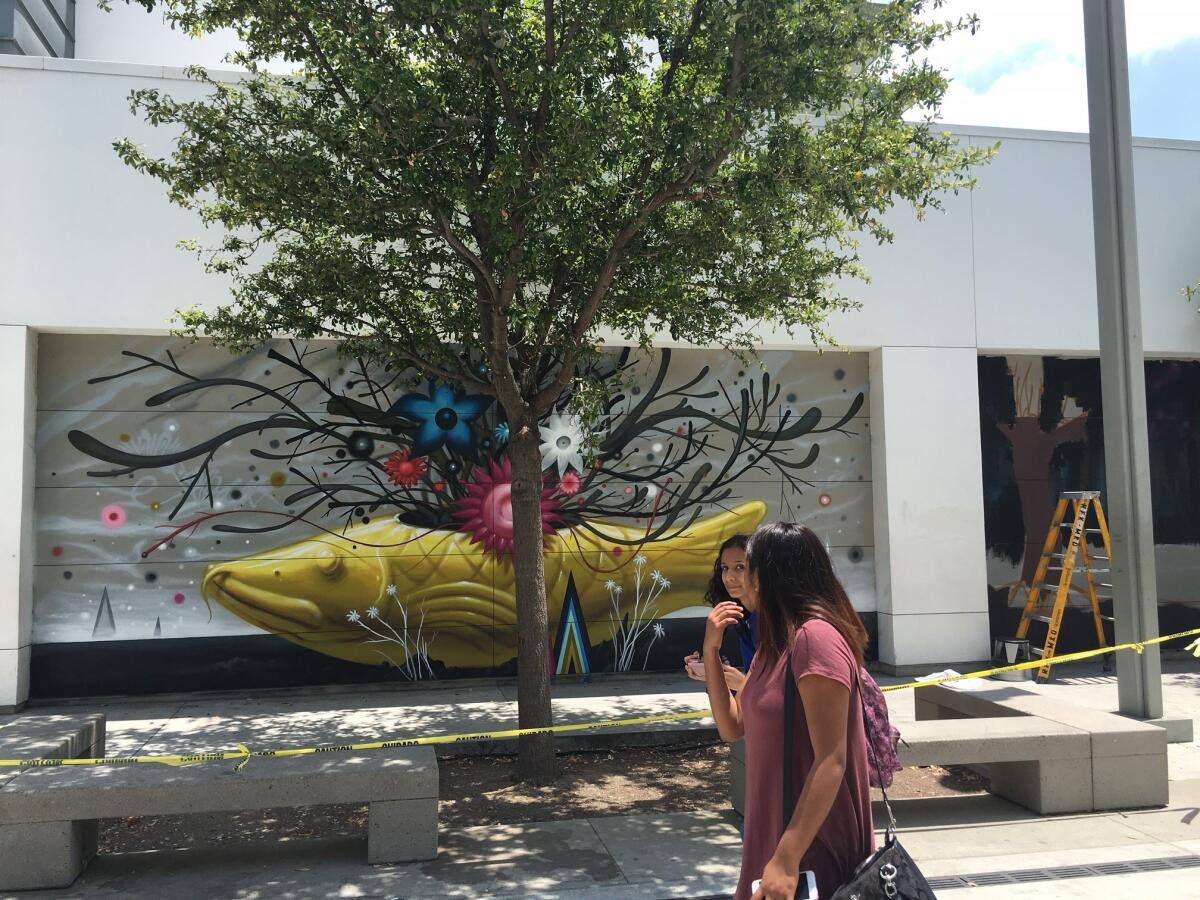 Students pass a mural by L.A. artist Jeff Soto.