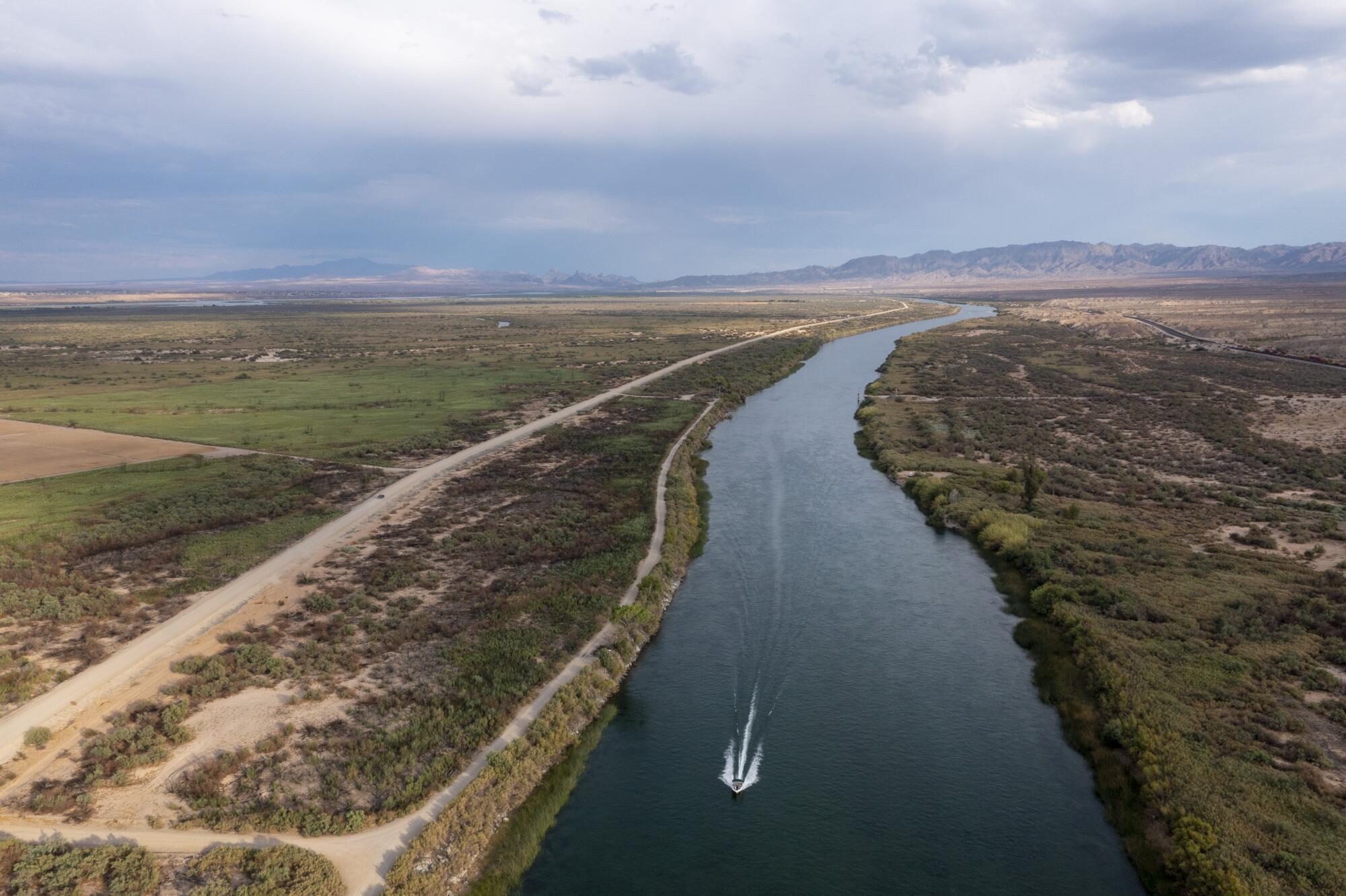 The Colorado River flows through the Mojave desert on the border of California, right, and Arizona, left, in Needles, Calif.