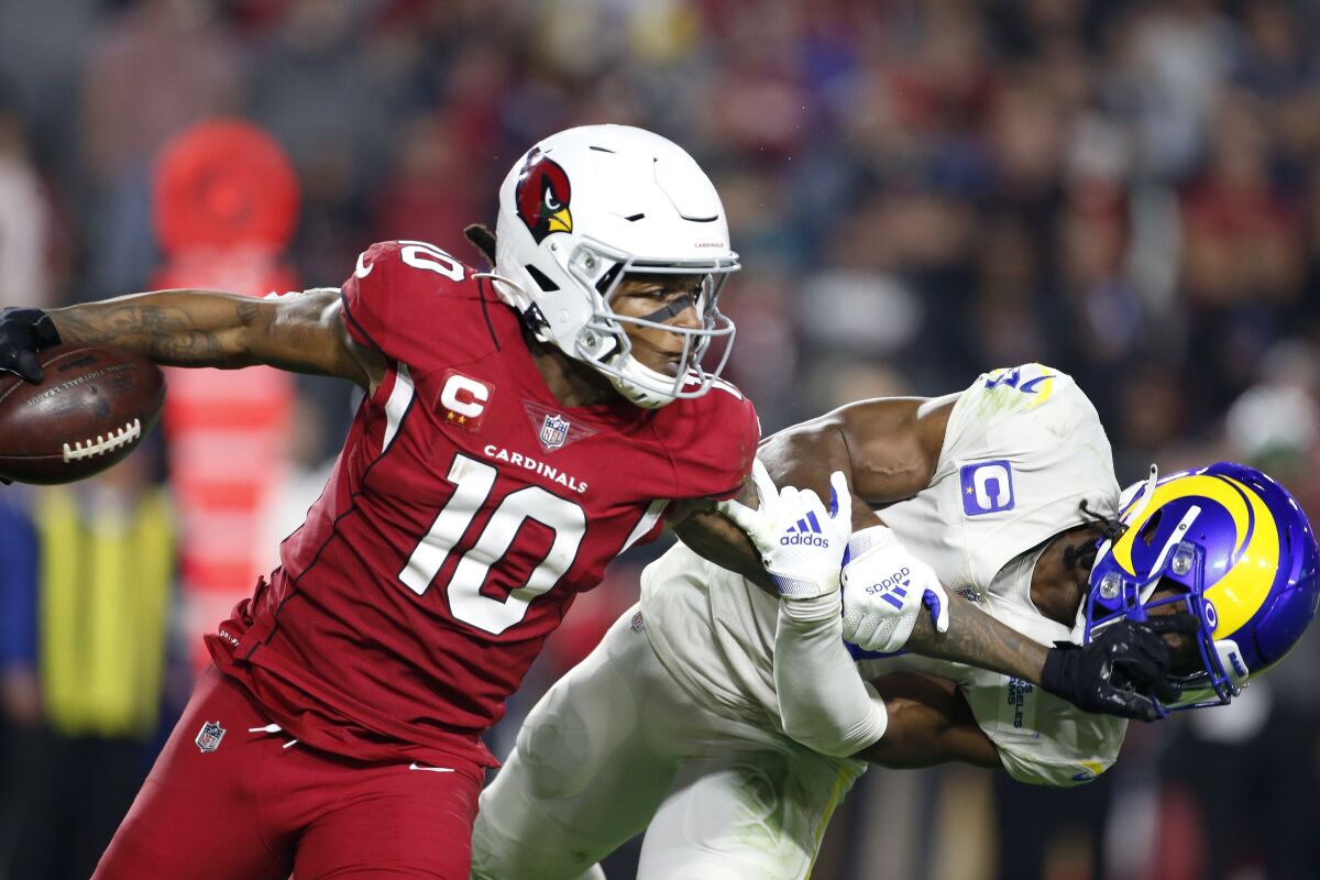 Arizona Cardinals wide receiver DeAndre Hopkins (10) gives Los Angeles Rams safety Jordan Fuller a stiff-arm after making a catch during the second half of an NFL football game Monday, Dec. 13, 2021, in Glendale, Ariz. (AP Photo/Ralph Freso)