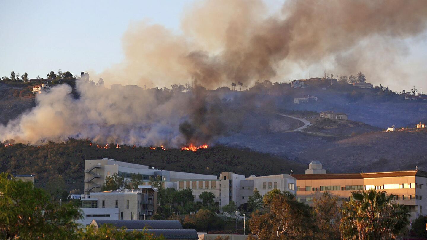 The Cocos fire burns in the hills above Cal State San Marcos on Thursday. The fire had burned 2,520 acres and was considered 70% contained by Saturday.