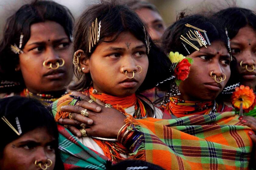 FILE - In this Sunday, Feb. 26, 2012 file photo, Indian girls from the Dongaria Kondh, an 8,000-strong tribe of indigenous people who consider the mineral-rich Niyamgiri hills sacred, watch sacrificial rituals during the annual festival of Niyam Raja in Lanjigarh at the sacred Hill, about 400 kilometers (249 miles) from the eastern Indian city of Bhubaneswar. In August 2010 India refused permission to London-based Vedanta Resources to mine bauxite for its alumina refinery in the Niyamgiri Hills citing violations of environmental and human rights laws. At least 200 land and environmental activists were slain in 2016 protecting forests, rivers and land from mining, logging and agricultural companies, the highest annual number on record, the London-based Global Witness said in a report said Thursday, July 13, 2017. India had a threefold increase in such killings but Latin America remained the deadliest region with some 60 percent of the world's deaths of activists protecting local resources. (AP Photo/Biswaranjan Rout, File)