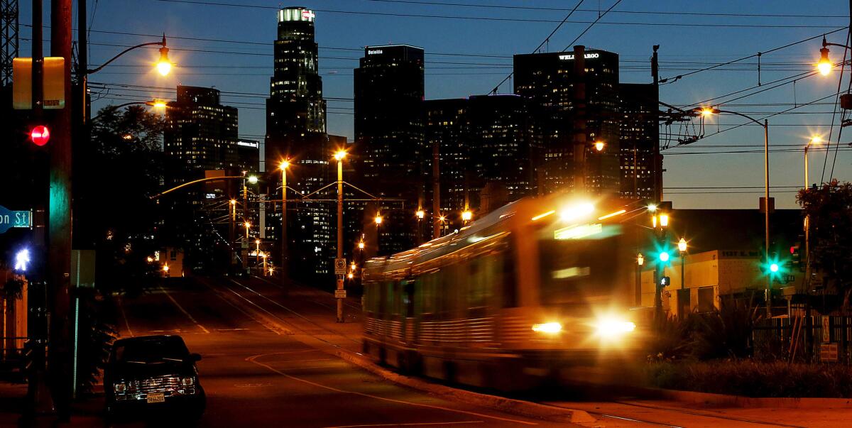 A Metro Gold Line train travels east from the city center as dusk descends on Los Angeles in October. The agency is considering a proposal to set aside some of its property for affordable housing development.