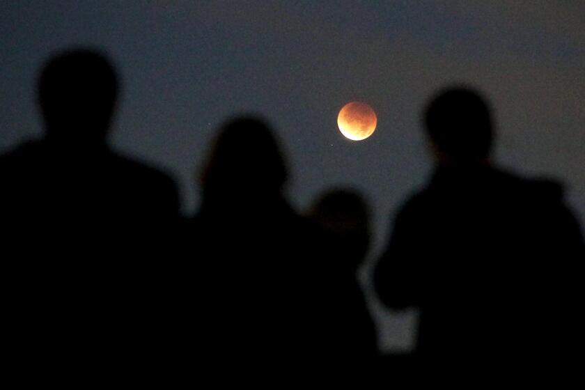 In this file photo of 2011, people gathered to view a full eclipse of the moon at Griffith Park Observatory in Los Angeles.