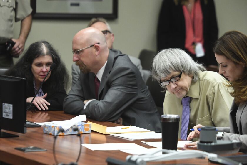 David Turpin, second from right, and wife, Louise, left, sit in a courtroom during their sentencing hearing Friday, April 19, 2019, in Riverside, Calif. The California couple who pleaded guilty to years of torture and abuse of 12 of their 13 children have been sentenced to life in prison with possibility of parole after 25 years. (Will Lester/The Orange County Register via AP, Pool)