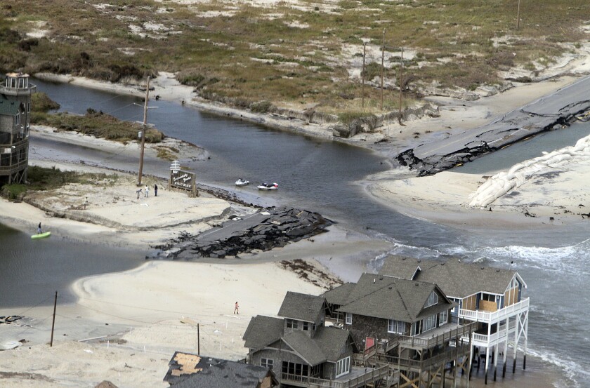 FILE - This aerial photo taken during a helicopter tour, on Tuesday, Aug. 30, 2011, with a group of federal and state officials, shows a section of Highway 12 at the edge of Rodanthe, N.C., that was destroyed by Hurricane Irene. A bridge that will allow locals and tourists to avoid the perennially washed-out route on North Carolina’s Outer Banks is set to open to traffic in April 2022. (Chris Seward/The News & Observer via AP, File)