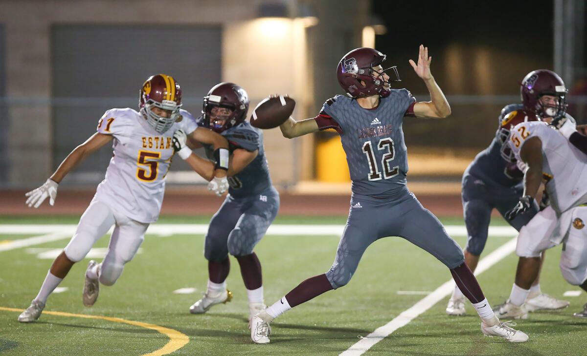 Laguna Beach quarterback Andrew Johnson (12) completes a long pass in a nonleague game against Estancia on Friday.