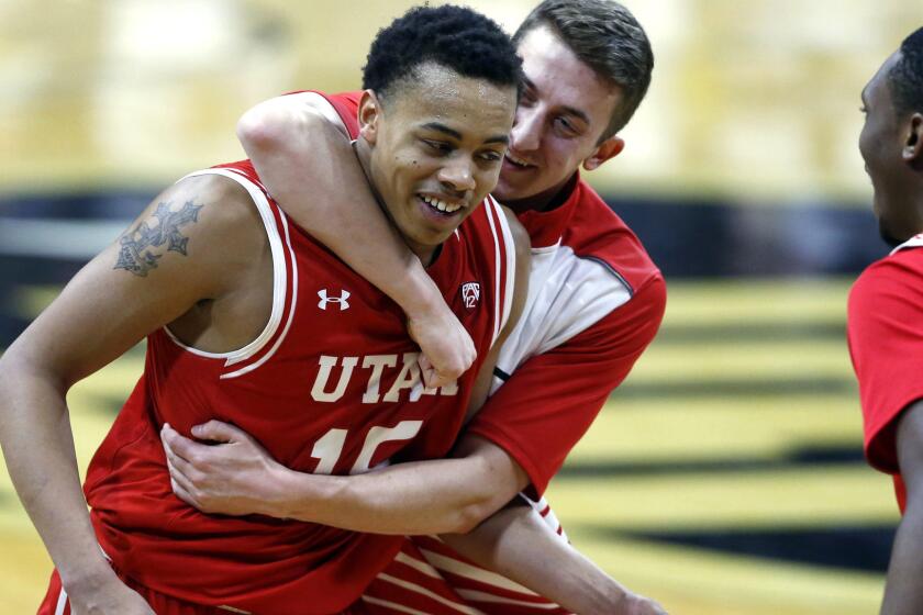 Utah guard Lorenzo Bonam is hugged by a teammate after scoring the winning basket against Colorado on Friday night.