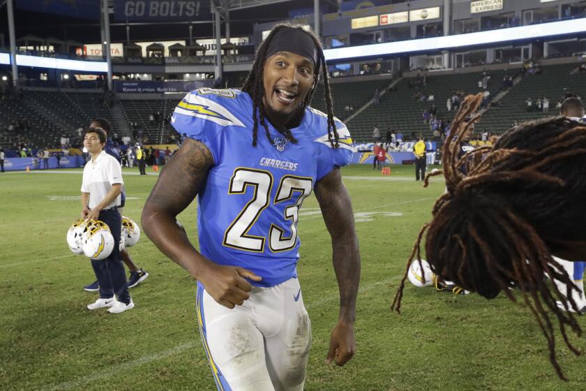 Los Angeles Chargers defensive back Rayshawn Jenkins, left, talks with Seattle Seahawks cornerback Ugo Amadi after a preseason NFL football game Saturday, Aug. 24, 2019, in Carson, Calif. (AP Photo/Gregory Bull)