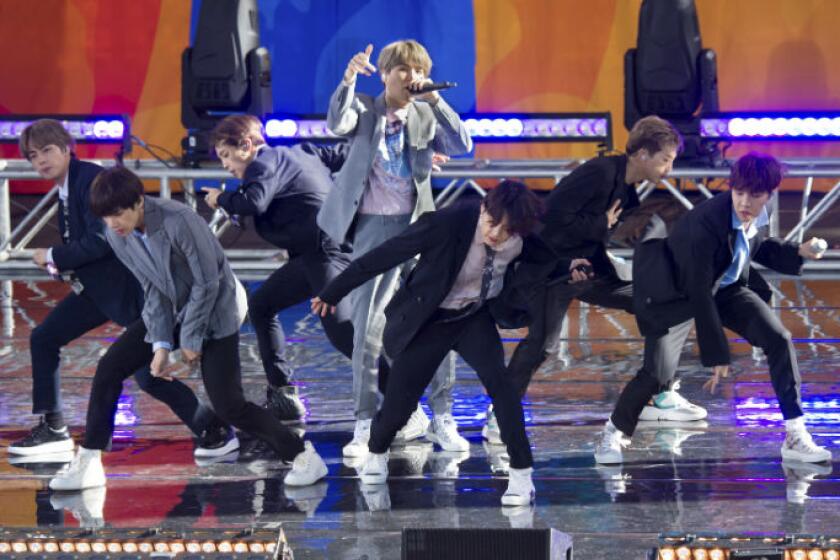 A group of men in suits singing and dancing on a stage