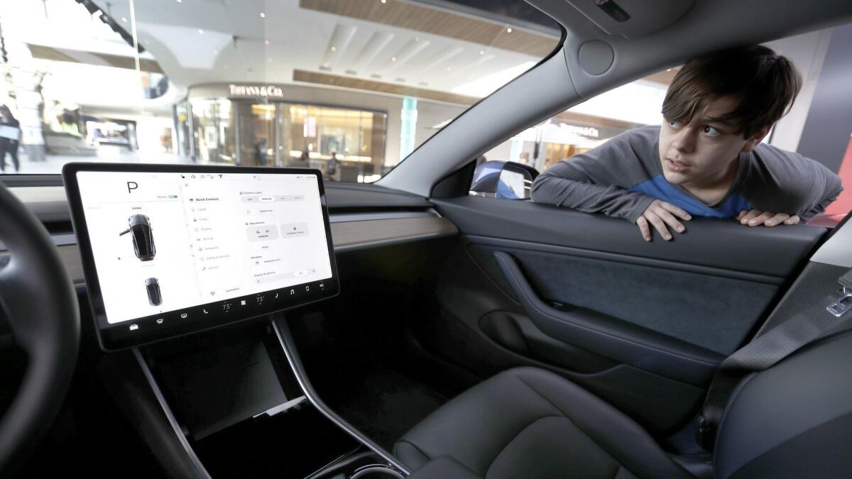 Andrew Gentleman, 12, of St. Louis checks out the interior of a Model 3 at a Tesla showroom in Century City last January.