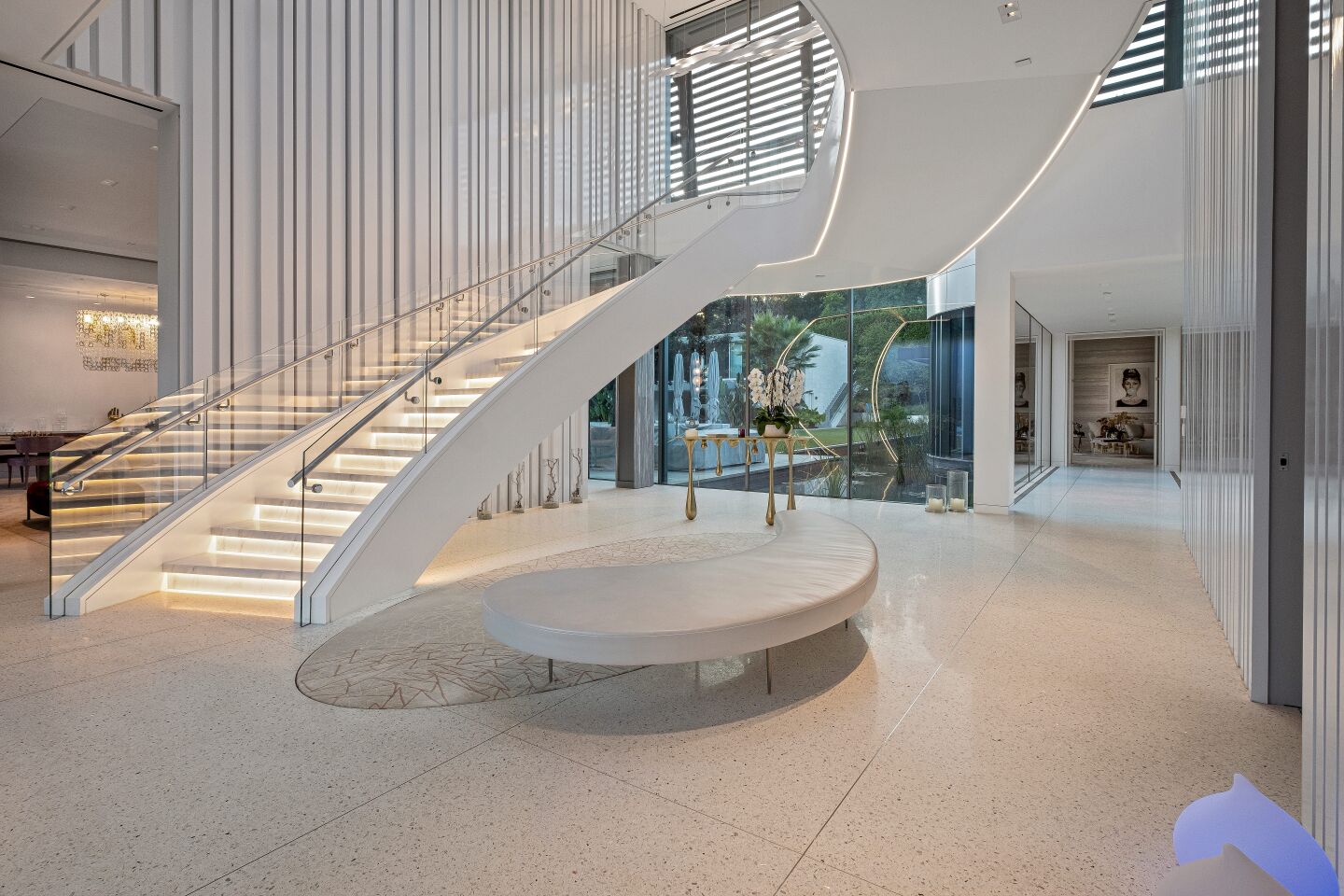 A sweeping staircase sits in the entry.