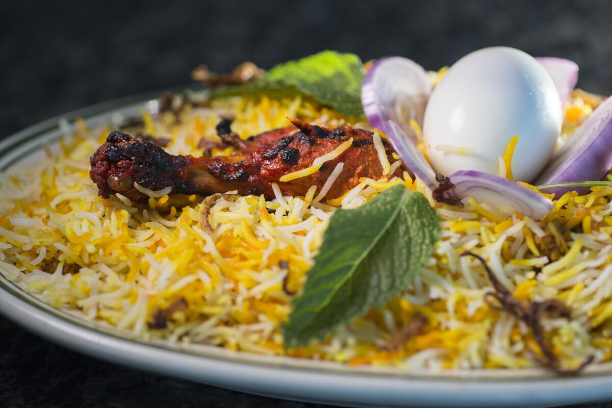 Chicken Dum Biryani is served with an egg and raw red onions at Kabob Corner Indian restaurant in Artesia, Calif.