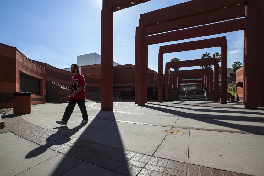 Los Angeles, CA - February 03: One of the two new COVID-19 vaccine center in California will be established at Cal State University. Savian Joseph, 20, after giving COVID-19 test walks under the arches of Harriet and Charles Luckman Fine Arts Complex at Cal State University on Wednesday, Feb. 3, 2021 in Los Angeles, CA.(Irfan Khan / Los Angeles Times)