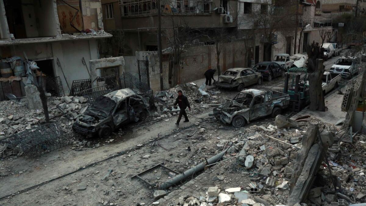 A Syrian man walks next to damaged buildings in February following government airstrikes in the rebel-held town of Duma in the besieged east Ghouta region on the outskirts of the capital, Damascus. The Syrian government has since retaken the area.