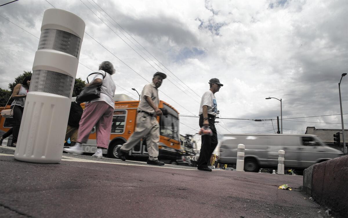 Traffic calming measures such as this red-painted crosswalk are part of L.A.'s Mobility Plan 2035, which backers say puts a new priority on road safety and expands the options for people who don’t want to drive.