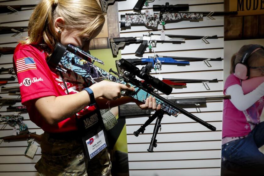 DALLAS,TX --SATURDAY, MAY 05, 2018-- Addyson "Alpha Addy" Soltau,9, tries out rifles in the Keystone Sporting Arms booth, maker of the Crickett youth rifle, which Soltau first learned to shoot with, at the 147th NRA Annual Meetings and Exhibits, in Dallas, TX, May 05, 2018. (Jay L. Clendenin / Los Angeles Times)