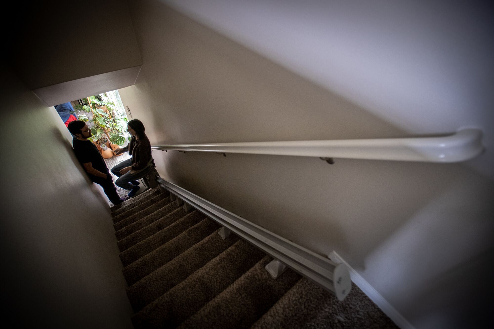 Courtney Garvin takes a break from coming down the stair lift from her room upstairs.