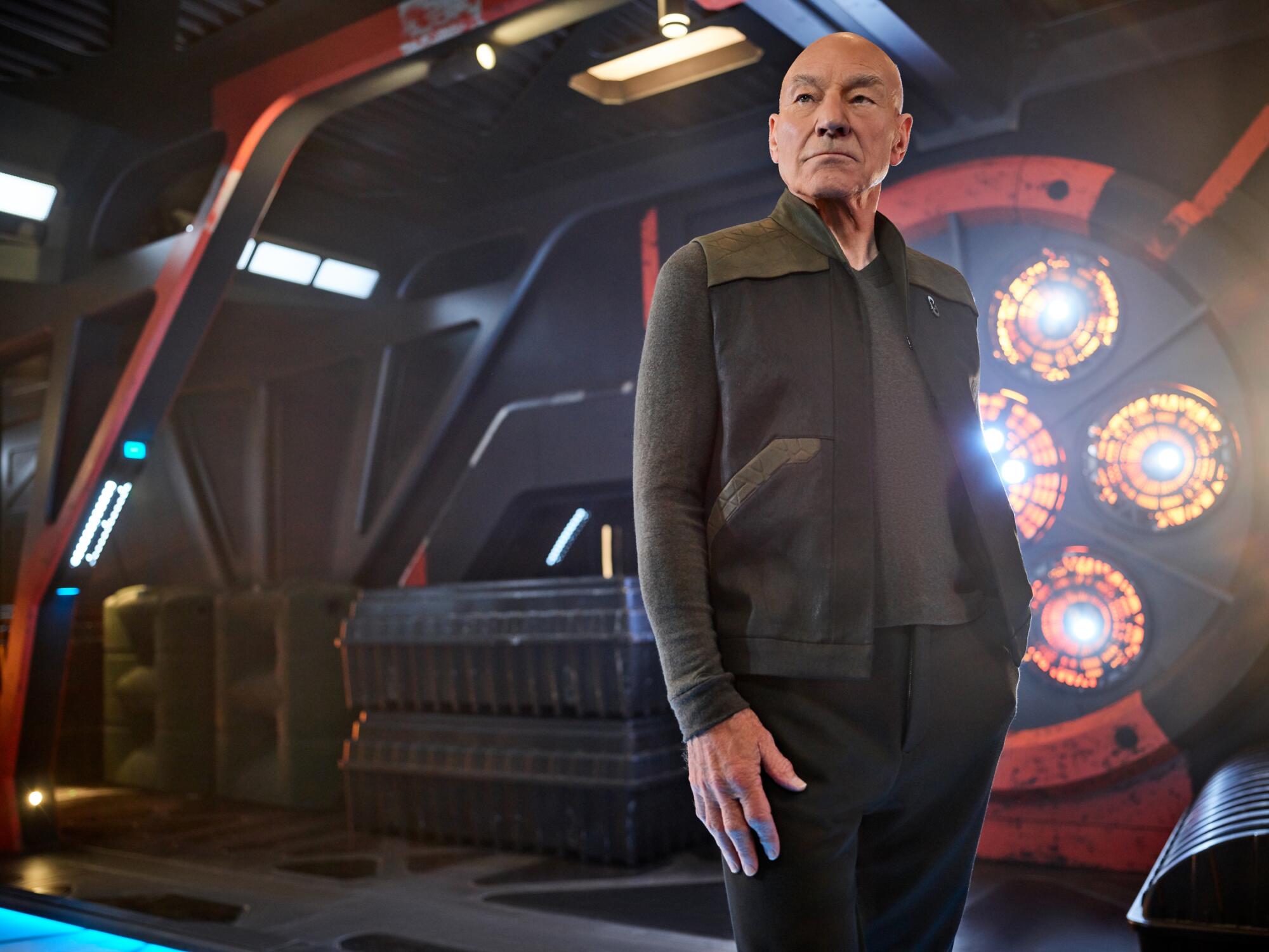 Jean-Luc Picard in dark clothing on a starship.