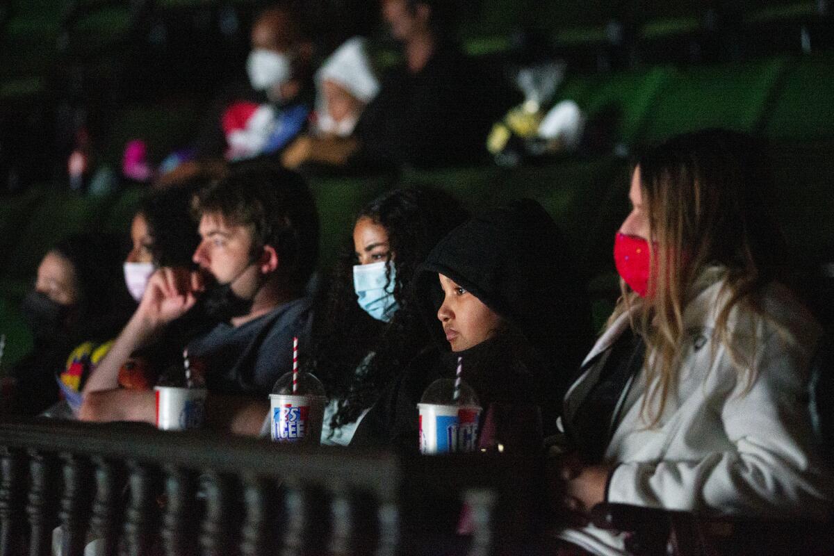Moviegoers wear masks as they watch a film at a Hollywood theater.