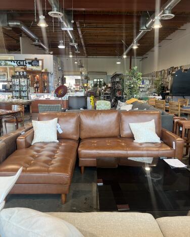 A leather couch and other furniture in a thrift store 