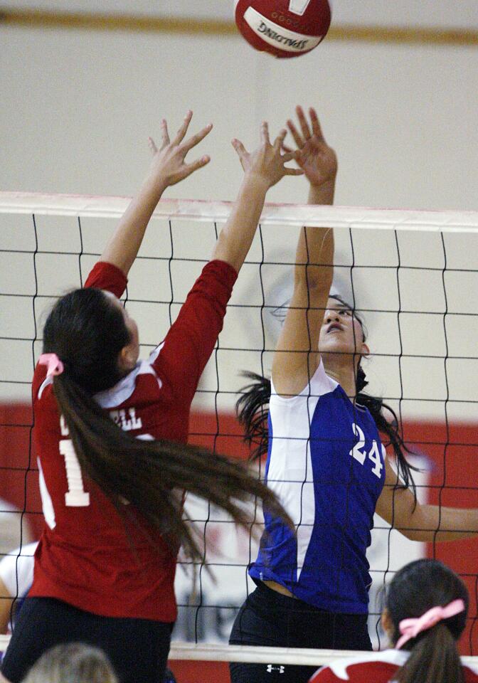 Burbank's Sharon Youn (24) and Burroughs Caitlin Cottrell battle for control of the ball at the net in a rival Pacific League girls volleyball match at Burroughs High School in Burbank on Thursday, October 4, 2012.