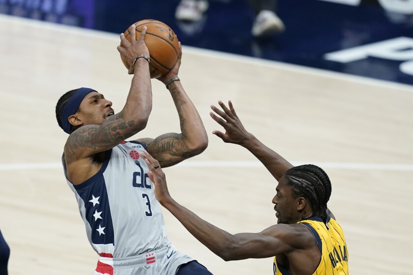 Washington Wizards' Bradley Beal (3) puts up a shot against Indiana Pacers' Justin Holiday (8) during the first half of an NBA basketball game, Saturday, May 8, 2021, in Indianapolis. (AP Photo/Darron Cummings)