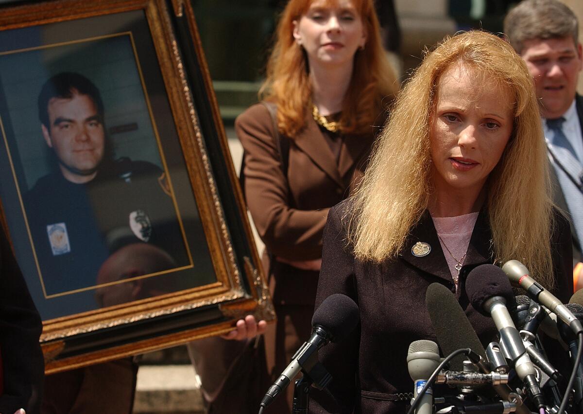 Felicia Sanderson, widow of Birmingham police officer Robert Sanderson (portrait) who was killed in the bombing of an abortion clinic, speaks to the reporters gathered in front of the federal courthouse Monday, July 18, 2005, in Birmingham, Ala., after confessed bomber Eric Rudolph was sentenced to life in prison without parole. (AP Photo/Birmingham News, Charles Nesbitt)