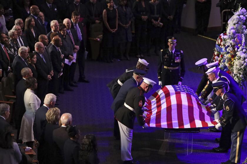 A military honor guard lays a U.S. flag on the casket of Rep. Elijah Cummings, D-Md., during his funeral service at New Psalmist Baptist Church in Baltimore, Md., on Friday, Oct. 25, 2019. (Chip Somodevilla/Pool via AP)